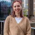 Portret van student met rood haar en beige trui, buiten